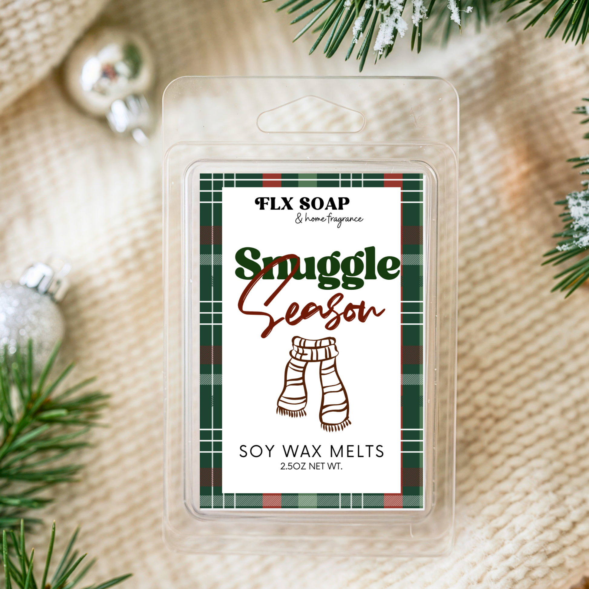 FLX SOAP 'Smuggle Season' soy wax melts packaging with Christmas decorations on a textured fabric background.